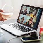 Happy Woman Celebrating On Christmas Virtual Video Call Party Cheering With Wine Online At Home 150x150
